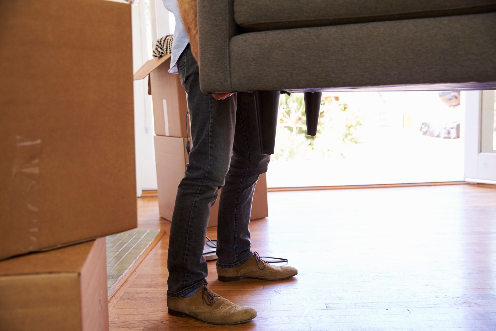 Close Up Of Man Carrying Sofa Into New Home On Moving